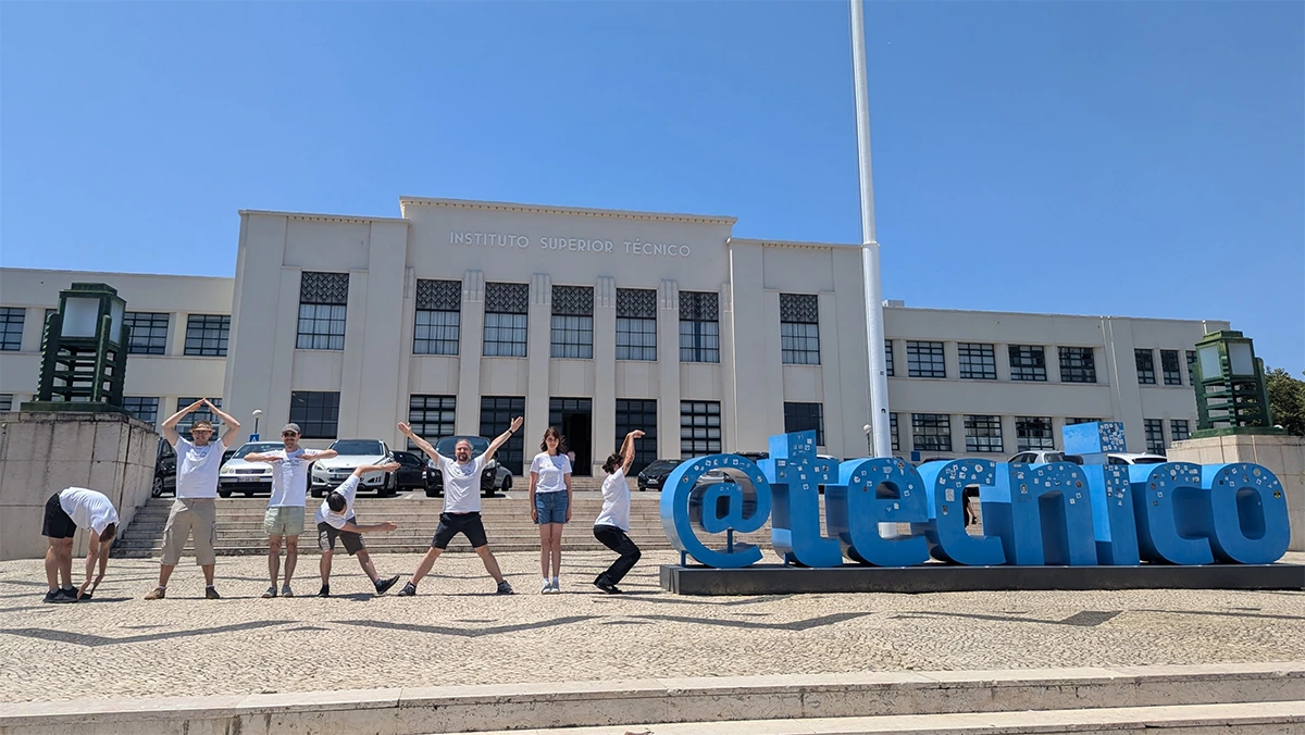 Seven WiMis at the Lisbon Machine Learning School: In front of the building of the host university, they form the lettering of their research group DATEXIS.